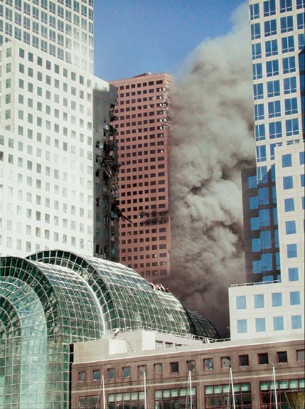 Figure 19. (9/11/01) WTC7 showing particulate emission emanating from East and North faces minutes before collapse, demonstrating pre-kinetic aerosol generation
